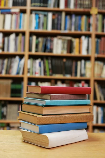 Kütüphanedeki masanın üzerinde kitap yığını