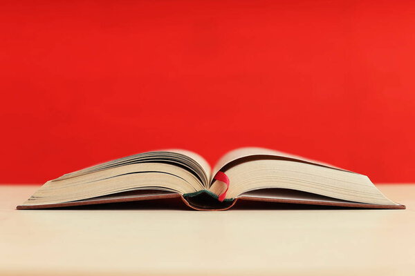 Open book on red background in library