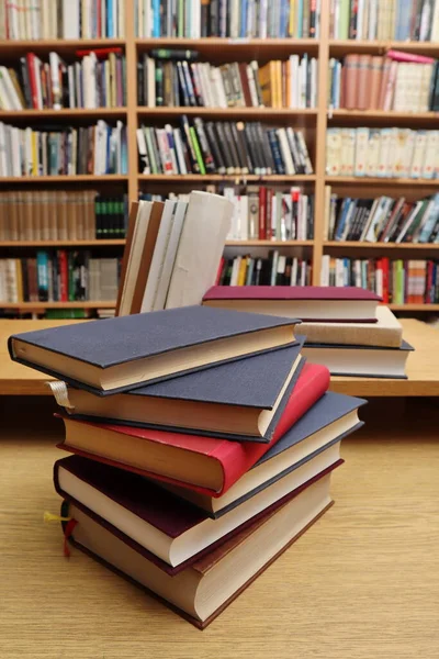 Kütüphanedeki masanın üzerinde kitap yığını