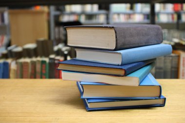 Kütüphanedeki masanın üzerinde kitap yığını