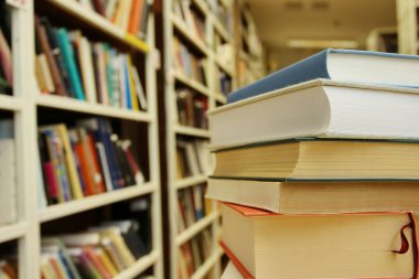 Kütüphanedeki masanın üzerinde kitap yığını