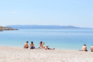 Makarska, Hırvatistan, 04.06.2021 İlk yüzücüler, Coronavirus salgınından sonra bu sezon ilk turistlerin geldiği Makarska 'daki plajların keyfini çıkarıyorlar.