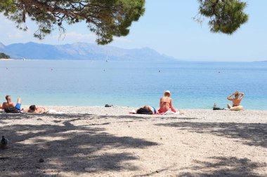 Makarska, Hırvatistan, 04.06.2021 İlk yüzücüler, Coronavirus salgınından sonra bu sezon ilk turistlerin geldiği Makarska 'daki plajların keyfini çıkarıyorlar.