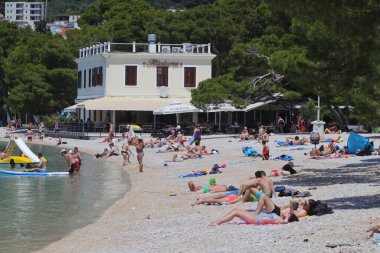 04.06.2021. Makarska, Hırvatistan, ilk yüzücüler, Coronavirus salgınından sonra bu sezon ilk turistlerin geldiği Makarska 'daki plajların keyfini çıkarıyorlar.