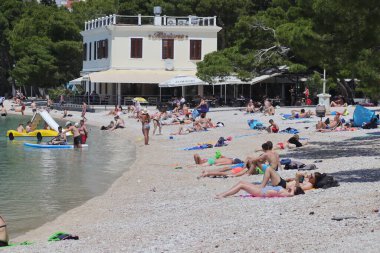 04.06.2021. Makarska, Hırvatistan, ilk yüzücüler, Coronavirus salgınından sonra bu sezon ilk turistlerin geldiği Makarska 'daki plajların keyfini çıkarıyorlar.