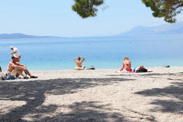 Makarska, Hırvatistan, 04.06.2021 İlk yüzücüler, Coronavirus salgınından sonra bu sezon ilk turistlerin geldiği Makarska 'daki plajların keyfini çıkarıyorlar.