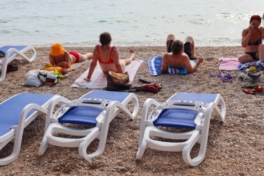 Makarska, Hırvatistan, 21.06.2021 Turist plajda dinleniyor, tatil boyunca deniz ve güneşin tadını çıkarıyor
