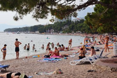 Makarska, Hırvatistan, 21.06.2021 Turist plajda dinleniyor, tatil boyunca deniz ve güneşin tadını çıkarıyor
