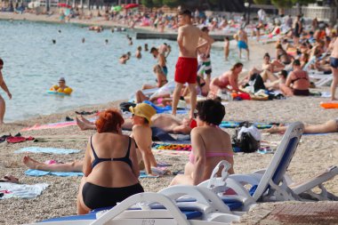 Makarska, Hırvatistan, 21.06.2021 Turist plajda dinleniyor, tatil boyunca deniz ve güneşin tadını çıkarıyor