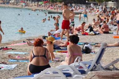 Makarska, Hırvatistan, 21.06.2021 Turist plajda dinleniyor, tatil boyunca deniz ve güneşin tadını çıkarıyor