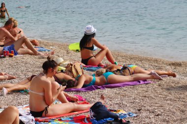 Makarska, Hırvatistan, 21.06.2021 Turist plajda dinleniyor, tatil boyunca deniz ve güneşin tadını çıkarıyor
