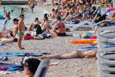 Makarska, Hırvatistan, 21.06.2021 Turist plajda dinleniyor, tatil boyunca deniz ve güneşin tadını çıkarıyor