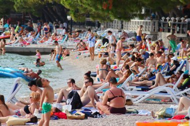 Makarska, Hırvatistan, 21.06.2021 Turist plajda dinleniyor, tatil boyunca deniz ve güneşin tadını çıkarıyor