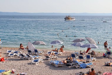 Makarska, Hırvatistan, 13 Temmuz 2021 Polonya, Almanya, Çek Cumhuriyeti, Slovakya ve Avusturya 'dan gelen turistler, Hırvatistan' ın güneyinde yer alan Makarska plajının keyfini çıkarıyorlar.