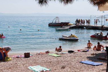 Makarska, Hırvatistan, 13 Temmuz 2021 Polonya, Almanya, Çek Cumhuriyeti, Slovakya ve Avusturya 'dan gelen turistler, Hırvatistan' ın güneyinde yer alan Makarska plajının keyfini çıkarıyorlar.