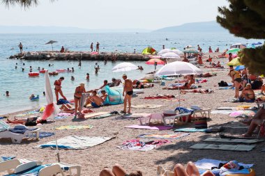 Makarska, Hırvatistan, 13 Temmuz 2021 Polonya, Almanya, Çek Cumhuriyeti, Slovakya ve Avusturya 'dan gelen turistler, Hırvatistan' ın güneyinde yer alan Makarska plajının keyfini çıkarıyorlar.