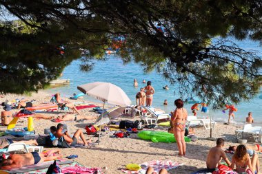 Makarska, Hırvatistan, 13 Temmuz 2021 Polonya, Almanya, Çek Cumhuriyeti, Slovakya ve Avusturya 'dan gelen turistler, Hırvatistan' ın güneyinde yer alan Makarska plajının keyfini çıkarıyorlar.