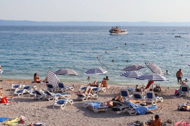 Makarska, Hırvatistan, 01.08.2021 Almanya, Polonya, Çek Cumhuriyeti, Slovakya, Avusturya ve Slovenya 'dan gelen turistler, Hırvatistan' ın güneyindeki plajlarda tatil yapıyorlar.