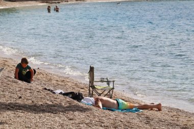 Hırvatistan 'ın Makarska kentinde Ekim ayı ortasında Hırvatistan' ın güneyinde 12.10.2025 plaj, turizm sezonu ve Hırvatistan 'da tatil deniz ve güneşin tadını çıkarıyor