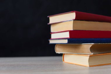 Tahta masadaki kitap yığını.