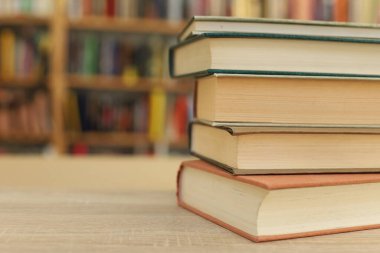 Kütüphanedeki masanın üzerinde kitap yığını