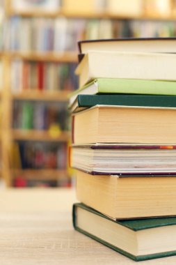 Kitapları kütüphanedeki ahşap masanın üstüne koy, yakın plan. Metin için boşluk