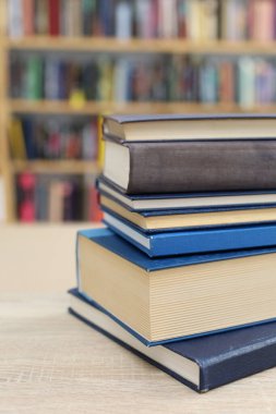 Kütüphanedeki masanın üzerinde kitap yığını