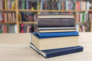 Kütüphanedeki ahşap masada yığınla kitap. eğitim ve öğrenim