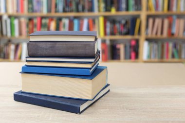 Kütüphanedeki masanın üzerinde kitap yığını