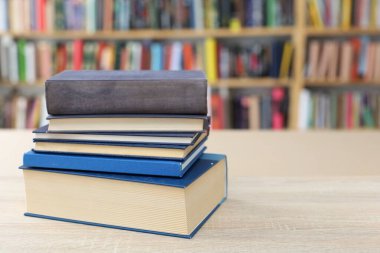 Tahta masadaki kitap yığını.