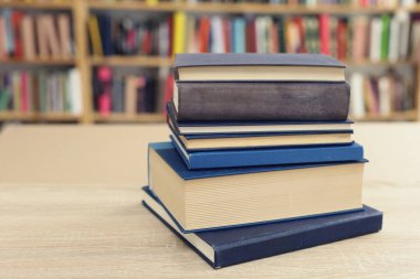 Tahta masadaki kitap yığını.