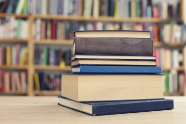 Tahta masadaki kitaplar bulanık arka plana karşı. Metin için boşluk