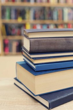 Kütüphanedeki masanın üstünde bir yığın kitap var.