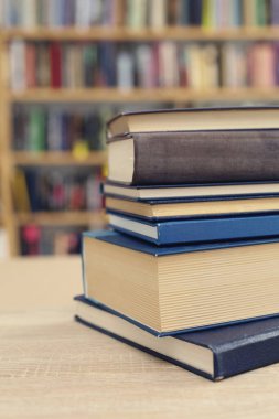 Tahta masadaki kitap yığını.