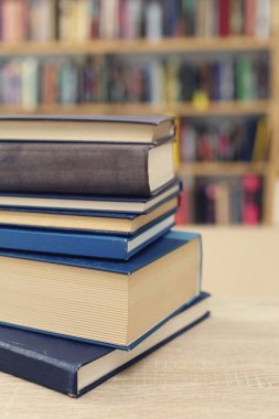 Kütüphanedeki masanın üzerinde kitap yığını