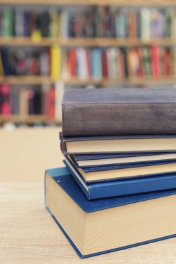 Kütüphanedeki masanın üzerinde kitap yığını