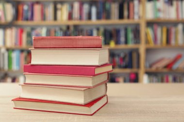 Tahta masadaki kitap yığını.