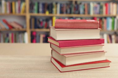 Kütüphanedeki masanın üzerinde kitap yığını