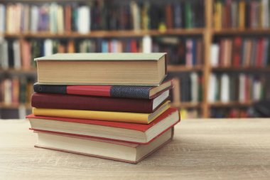 Bulanık arkaplanın önündeki ahşap masada kitaplar
