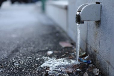 Buz, donmuş, siyah arka planda su musluğu, şehirde su musluğu.,