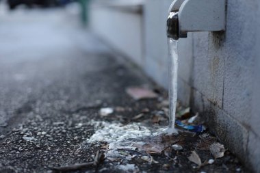 Buz, donmuş, siyah arka planda su musluğu, şehirde su musluğu.,