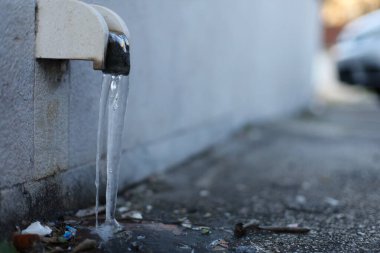 Buz, donmuş, siyah arka planda su musluğu, şehirde su musluğu.,