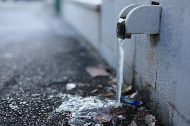 Buz, donmuş, siyah arka planda su musluğu, şehirde su musluğu.,