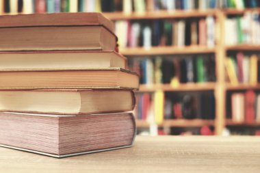 Kütüphanedeki masanın üzerinde kitap yığını