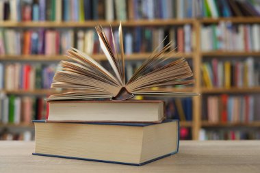 Kütüphanedeki masanın üzerinde kitap yığını