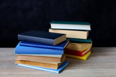 Tahta masadaki kitap yığını.