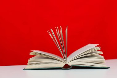 Renkli ahşap arkaplan üzerine açık kitap ve kırmızı sayfalar