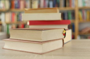 Kütüphanedeki masada yığınla kitap var.