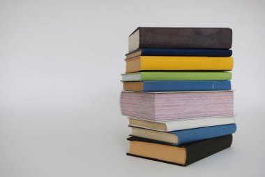 Beyaz arkaplan önünde kitap yığını