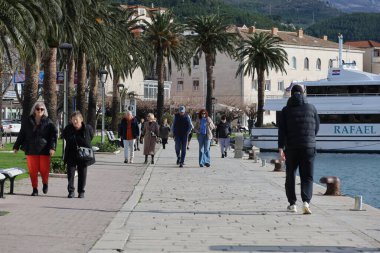 Makarska, Hırvatistan, 01.02.2026.İnsanlar kışın başında liman boyunca yürüyorlar.